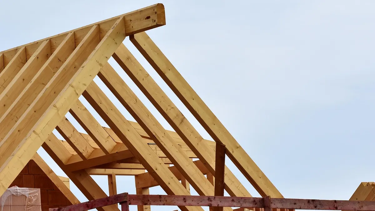 Dachstuhl aus Holz auf einem Neubau mit Richtkranz